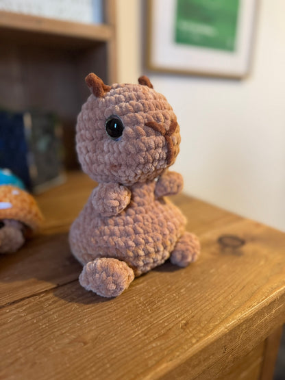 Crocheted animal toy on a wooden surface with a blurred background