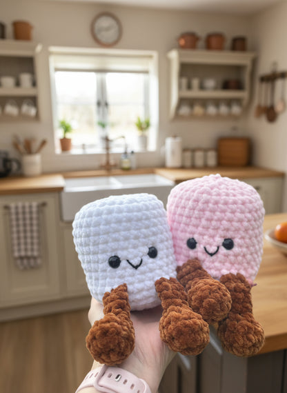Two small plush toys resembling ice cream cones held in a hand 