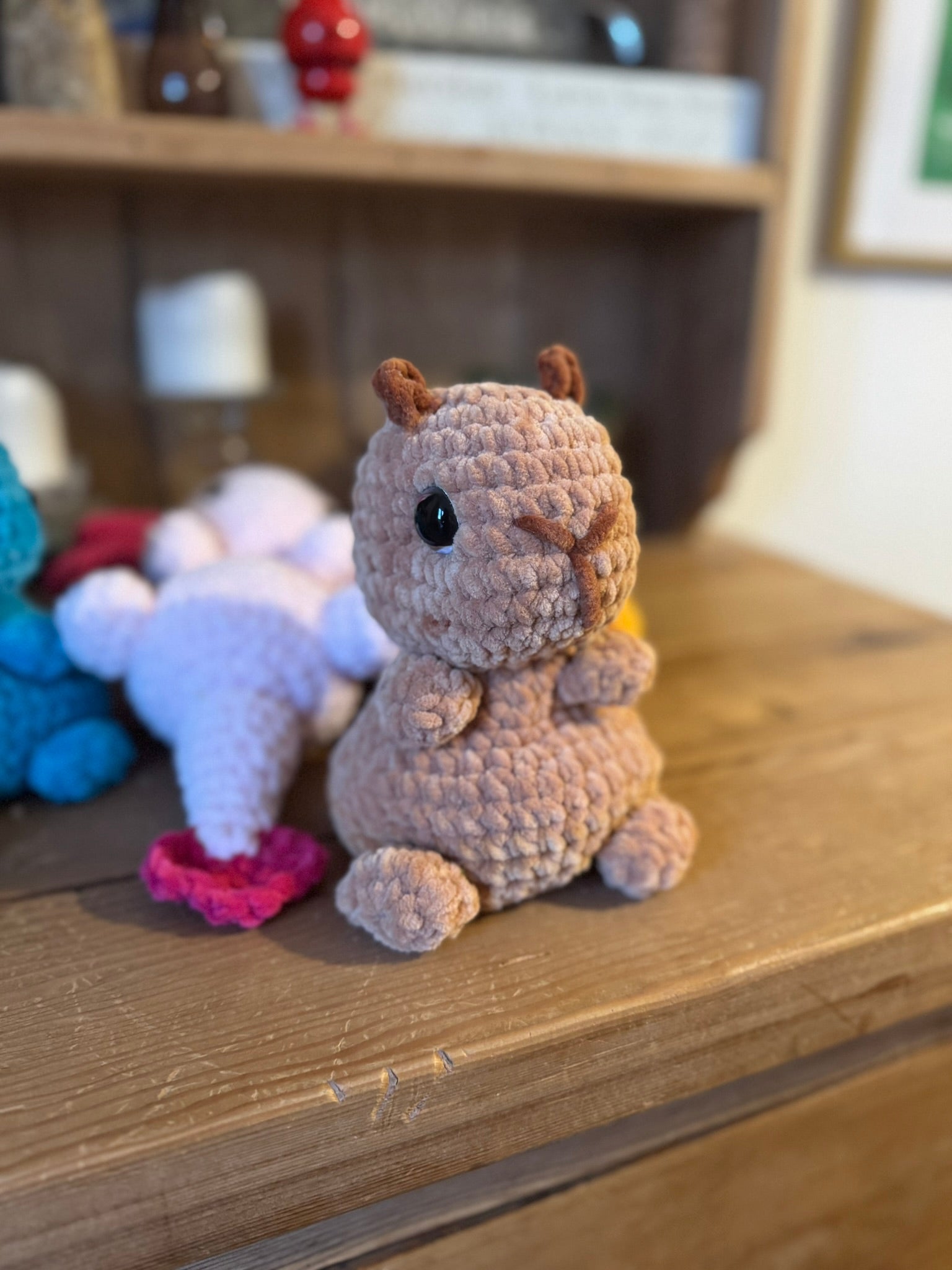 Crocheted animal figurine on a wooden surface with a blurred background