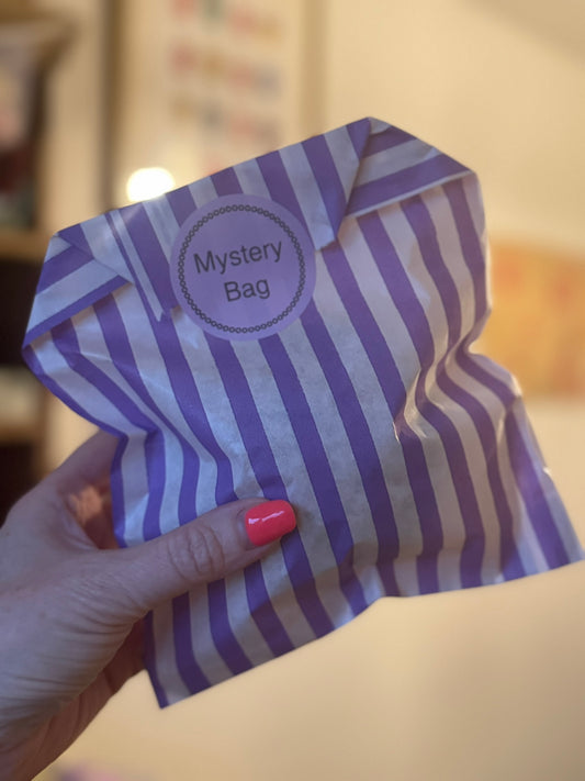 Purple and white striped bag labeled 'Mystery Bag' held by a hand.