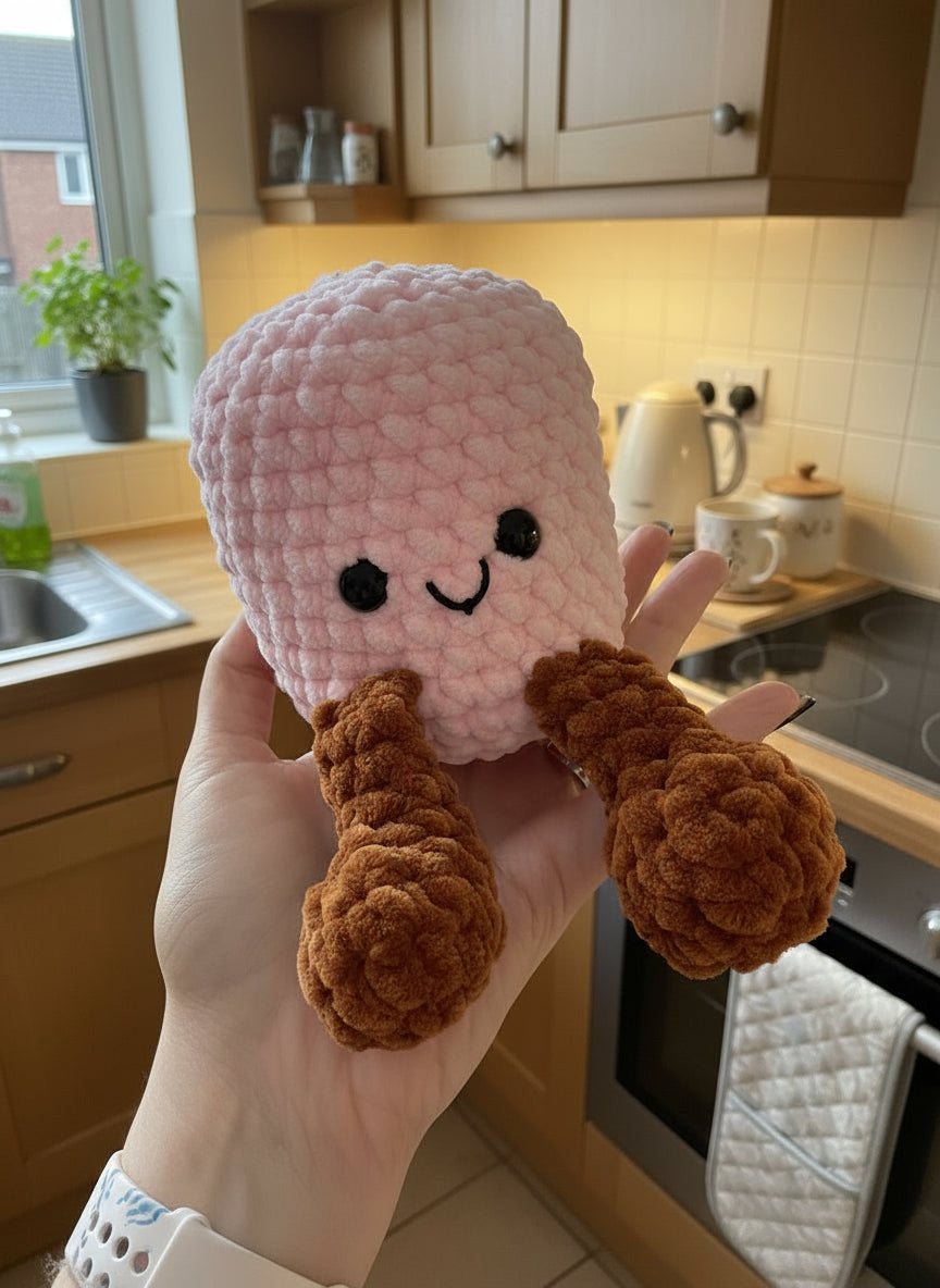 Hand holding a pink and brown plush marshmallow